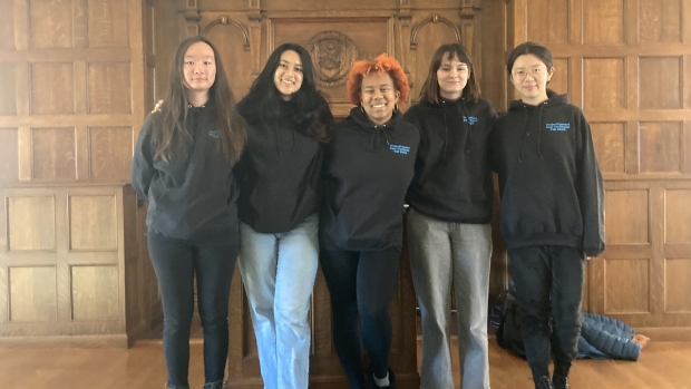 Smiling students pose together in Project Connect hoodies