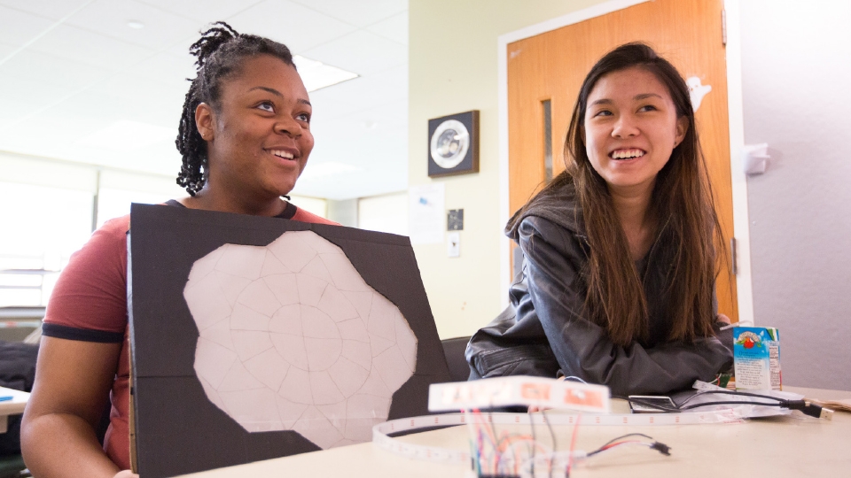 Two students working in a classroom Image of two students working in classroom
