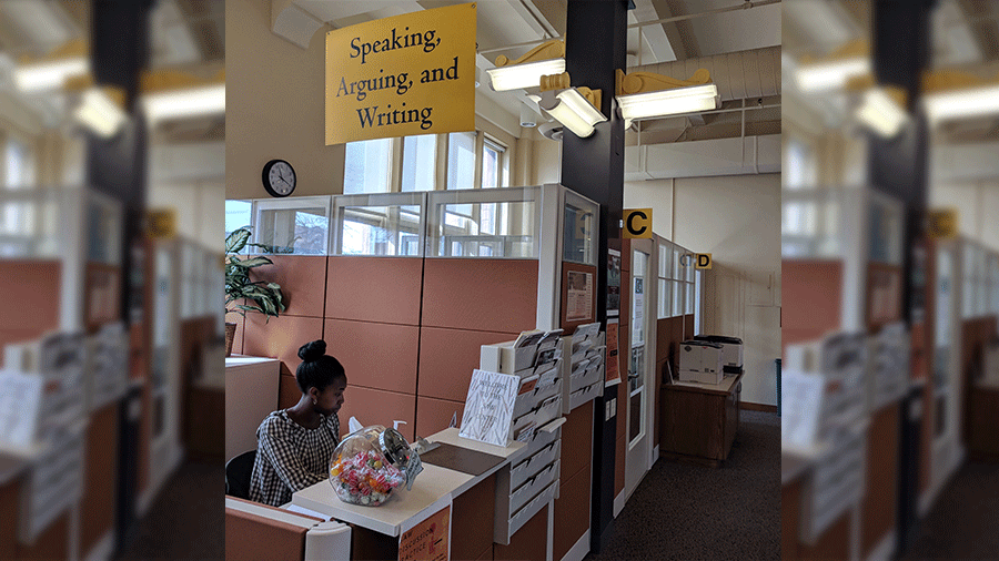 Photo of the SAW Center front desk with a student sitting behind the reception counter.